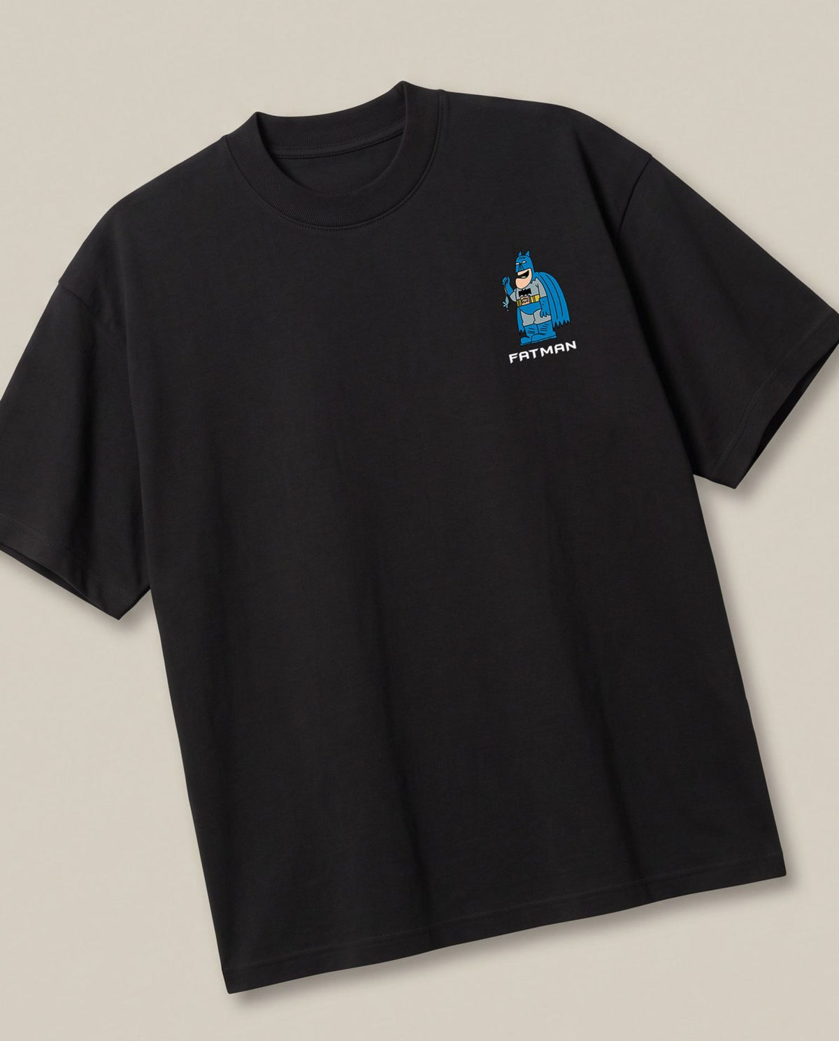 Fatman Black oversized t-shirt — fat batman giving competition to penguin, angled view