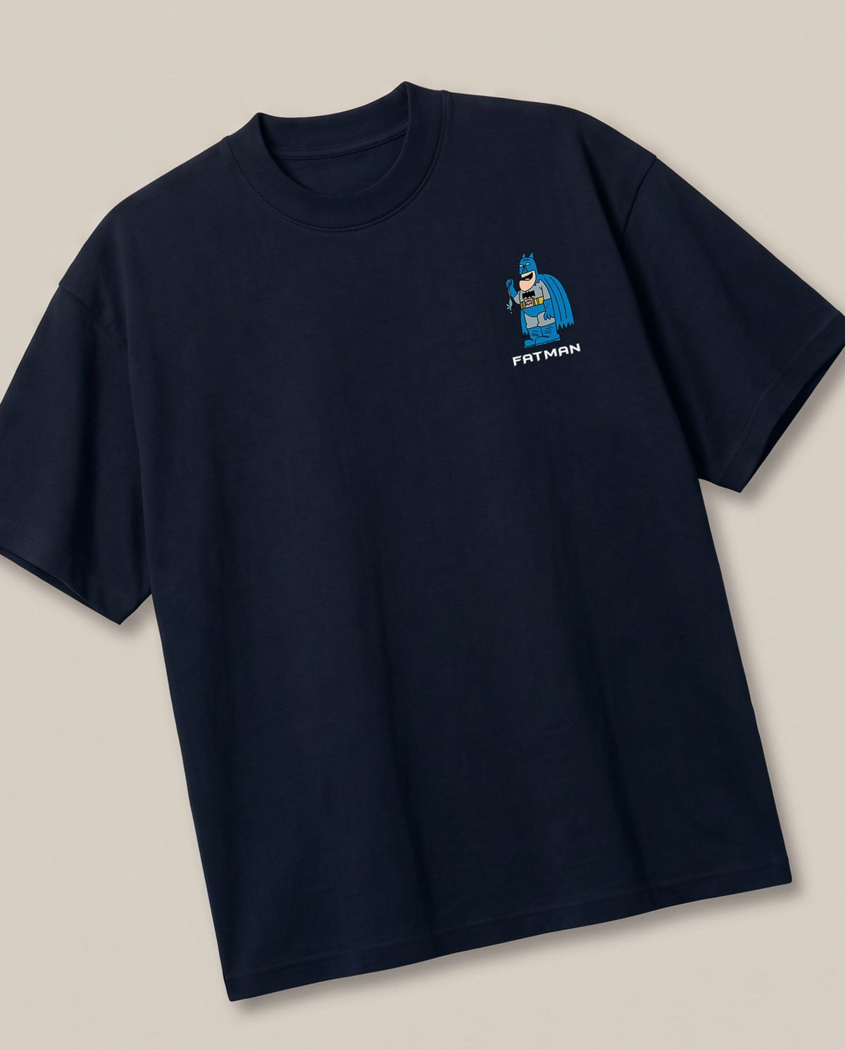 Fatman Navy oversized t-shirt — fat batman giving competition to penguin, angled view